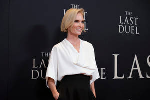Blonde woman in white blouse and black pants smiling at film event. — Duel Wallpaper