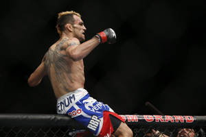 MMA fighter throwing a punch inside an octagon cage. — Winner Wallpaper