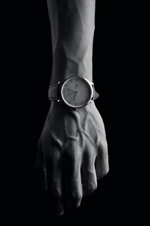 En hånd, der bærer et slankt minimalistisk ur i sort og hvidt. — Ur Wallpapers