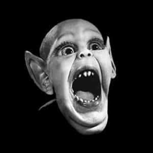 Un rostro de duende gritando con ojos muy abiertos y dientes afilados en blanco y negro. — Fotos de perfil Imágenes