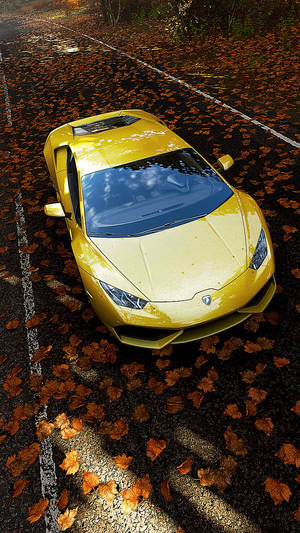 Yellow sports car surrounded by fallen autumn leaves on a road at sunset. — Lamborghini Wallpaper