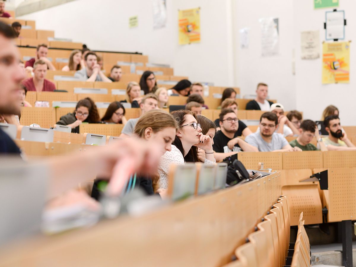 Aufmerksame Zuhörer im vollen Hörsaal.